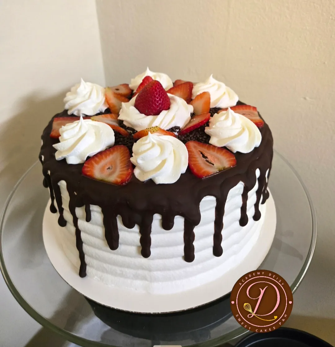 Cake con drip de chocolate, copetes de chantilly y fresas naturales